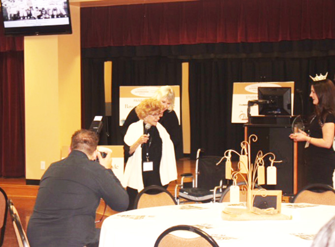 YA’LISHA GATEWOOD/Courtesy photo Dorothy Rourk stands from her wheel chair to accept her award during the Louisiana Monroe Women’s Symposium.